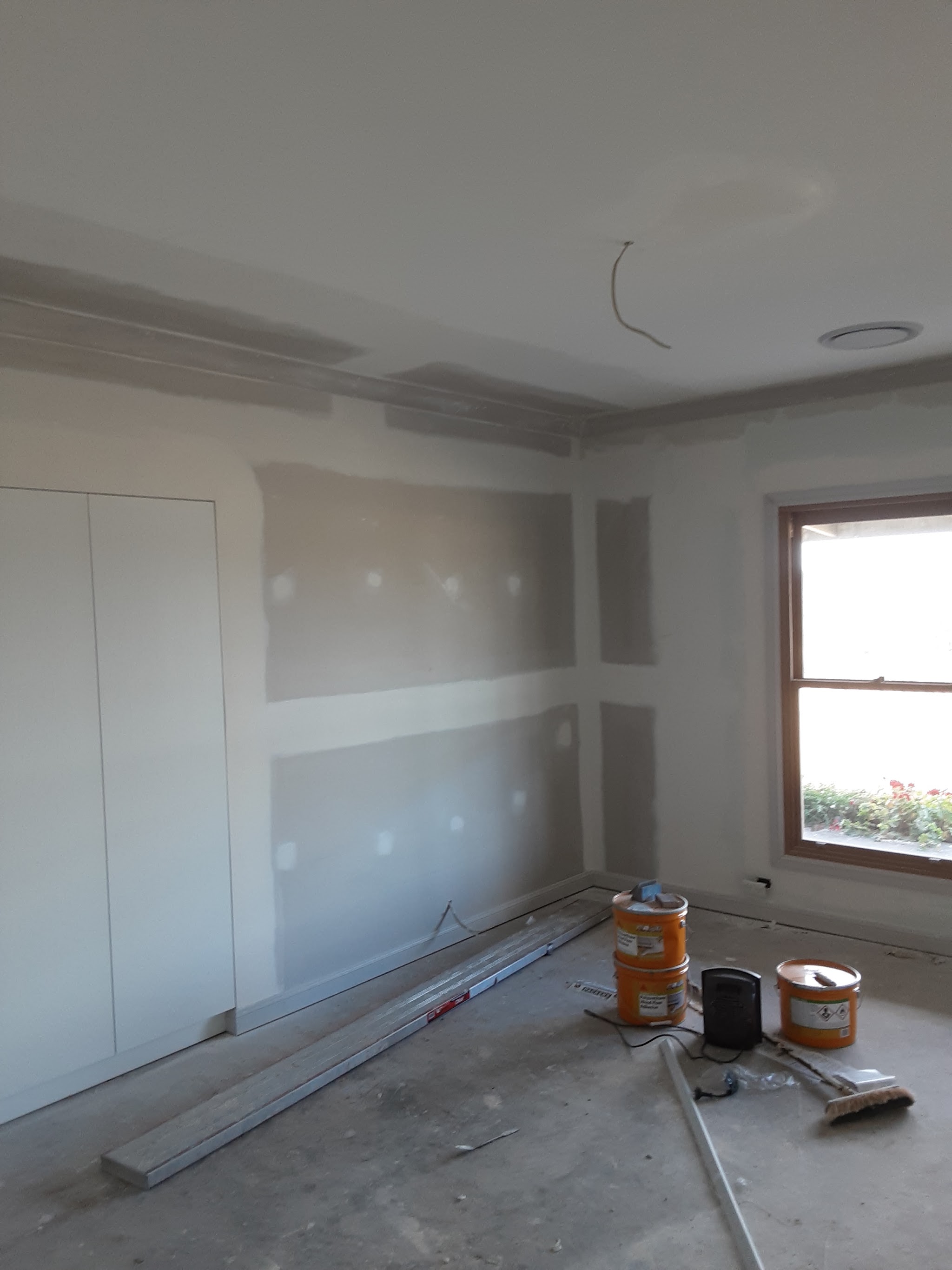 A finished bedroom set and sanded ready for paint, with a curved corner return beside a built in robe